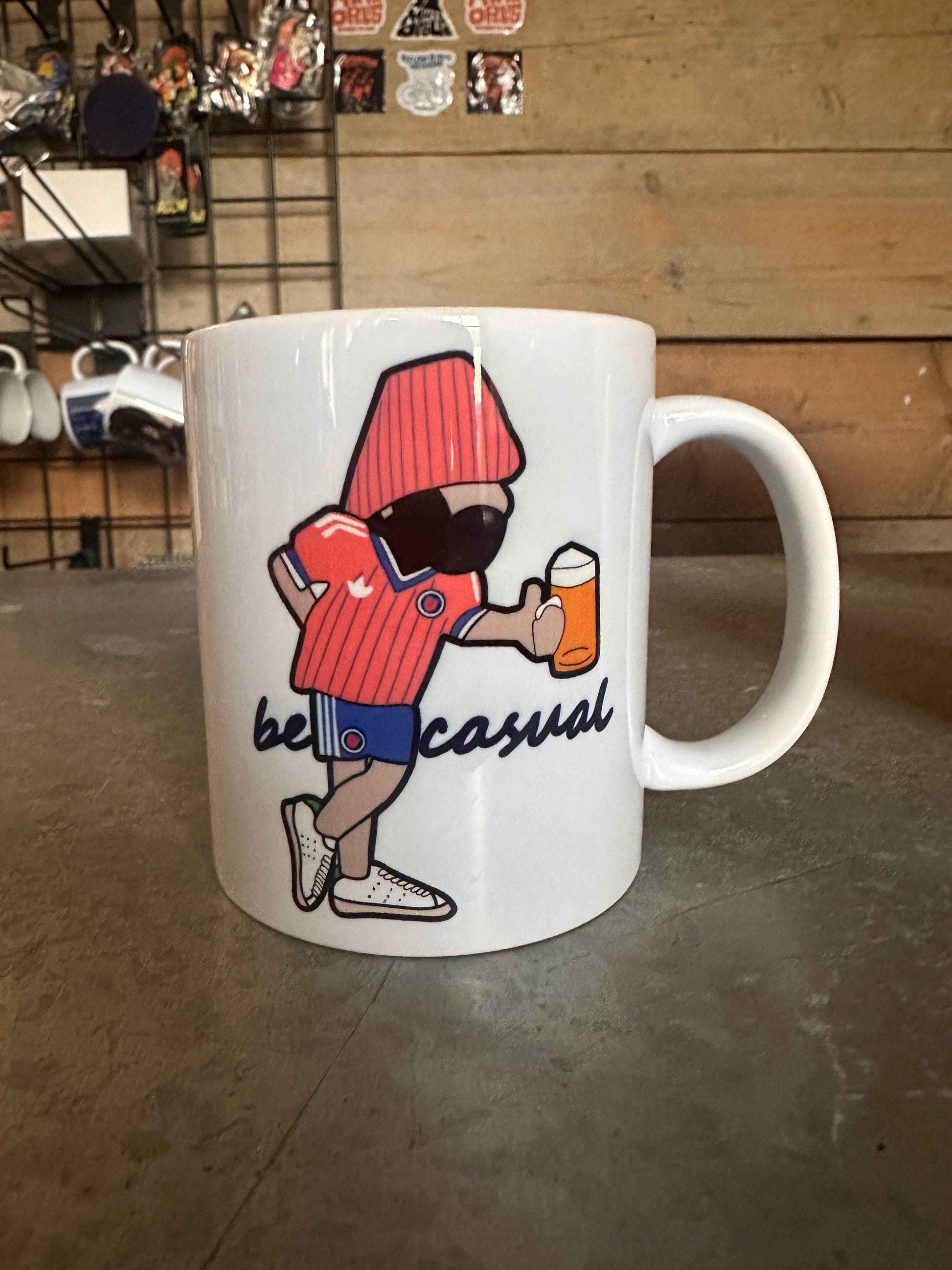 White mug with cartoon character and text on a concrete floor